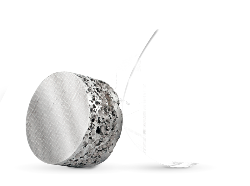 Ein rundes Stück Metallschaumstoff mit einer weißen Feder